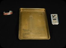 Image of woman's bracelet, brass tray, and compact from 1933 Worlds Fair. 