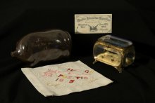 Image of Anna Pottery pig flask, cotton handkerchief, fair ticket, and souvenir box from 1893 Worlds Fair.